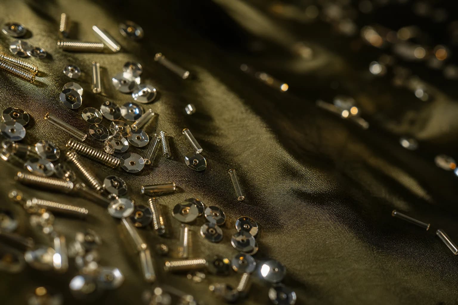 Sequins and coiled dabka catching the light on olive silk